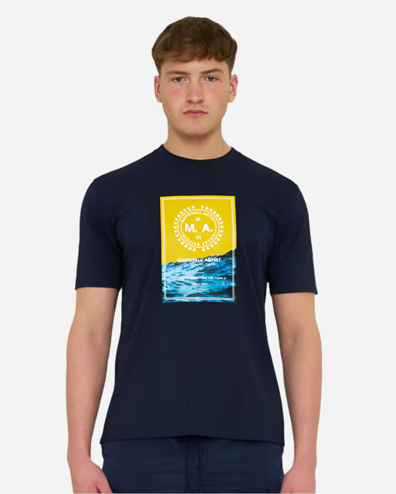Model wearing Marshall Artist CANUTE T Shirt in Navy, featuring coastal graphic and lightweight cotton for street style.