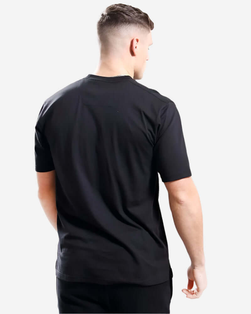 Model wearing the back view of a black Marshall Artist SIREN T Shirt, showcasing its classic design and comfortable fit.