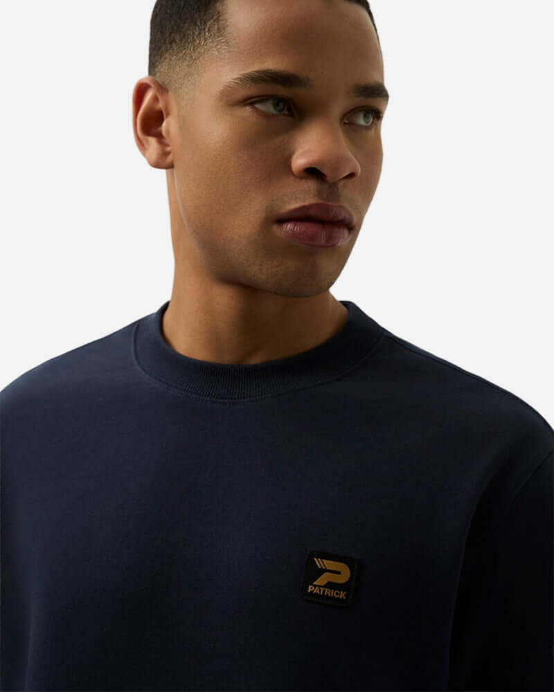 Patrick OSCAR Crew Sweat Top Navy worn by a model showcasing its stylish details and signature patch.