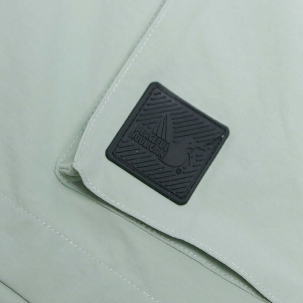 Close-up of the Peaceful Hooligan logo patch on mint BOWLER Shorts, showcasing quality and style.
