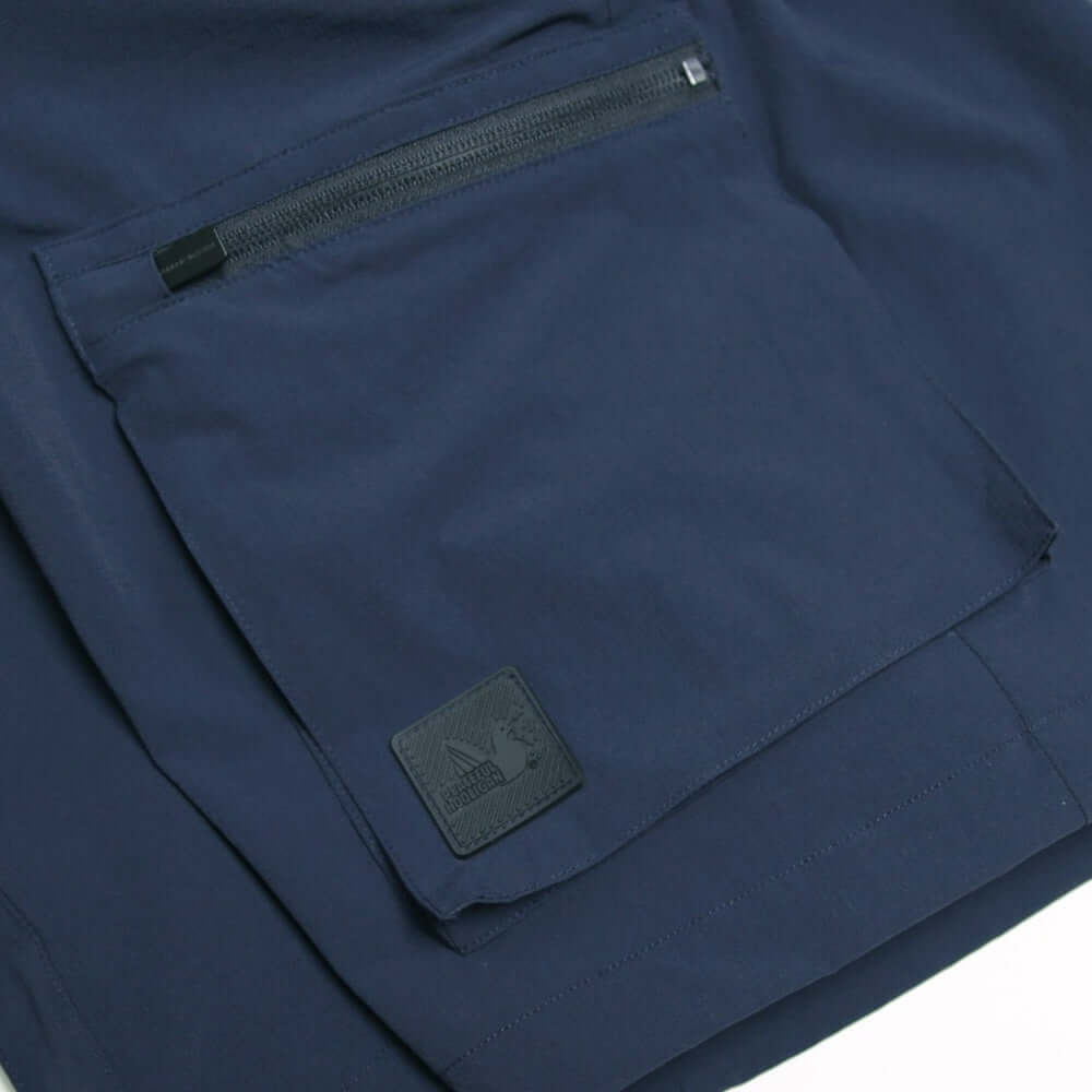 Close-up of Peaceful Hooligan BOWLER Shorts navy, featuring cargo pocket with zip fastening and branded tag.