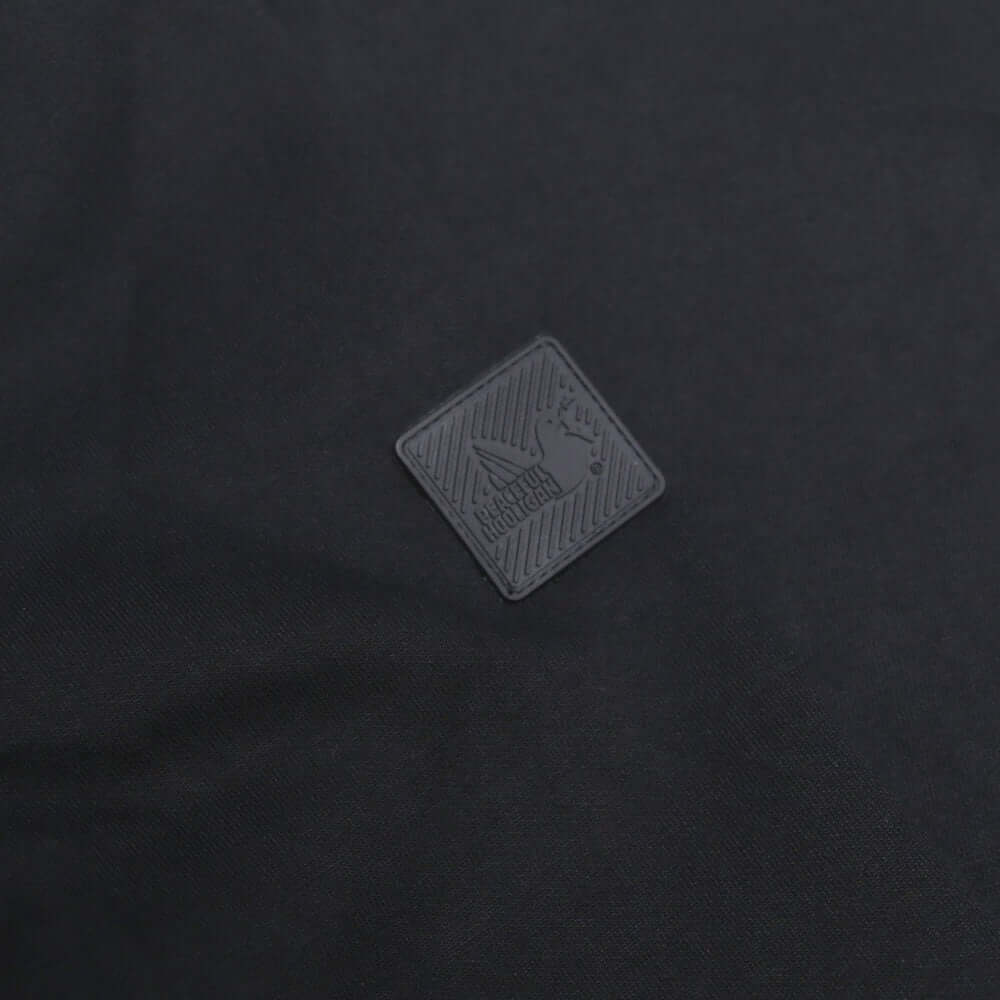 Peaceful Hooligan Dove Block badge detail on the black CONQUEST jacket, showcasing premium branding and style.