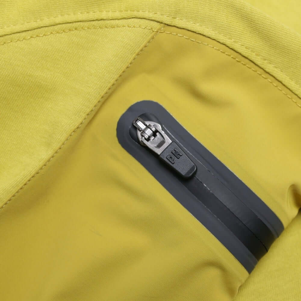 Detail of the sleeve pocket on the Peaceful Hooligan FORGE T Shirt Acid Mustard, featuring a zipper and stretch nylon design.