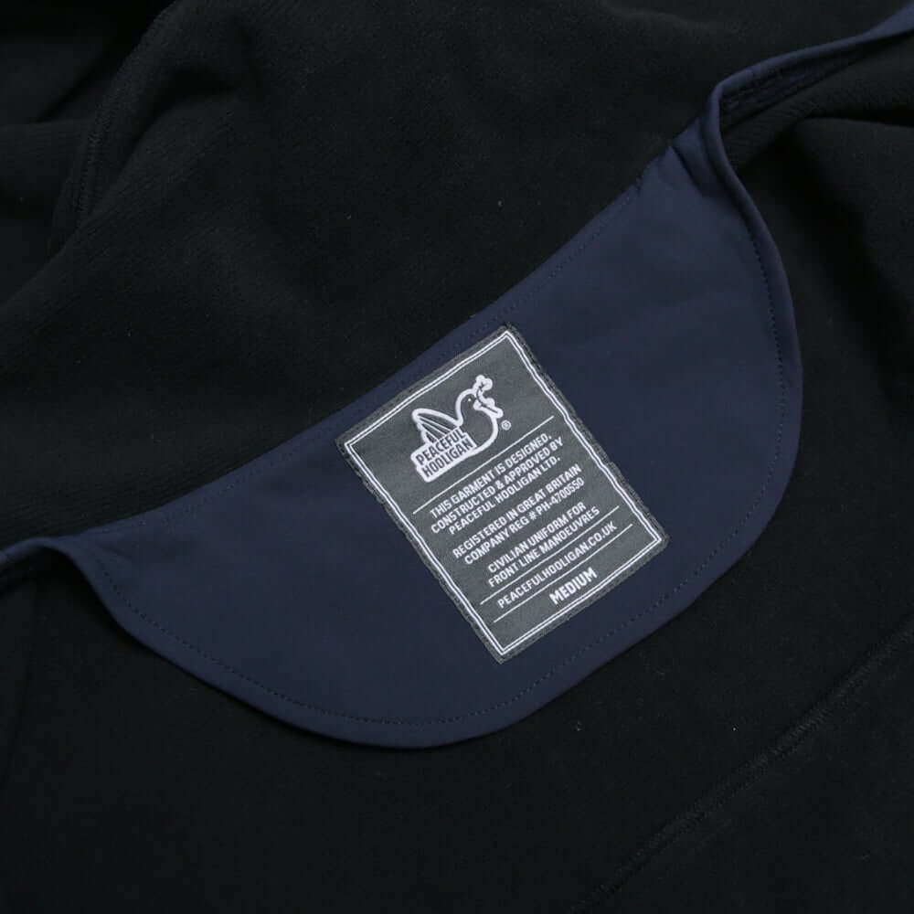 Label of the Peaceful Hooligan MARKSMAN Softshell Jacket in Navy, showing care instructions and size information.