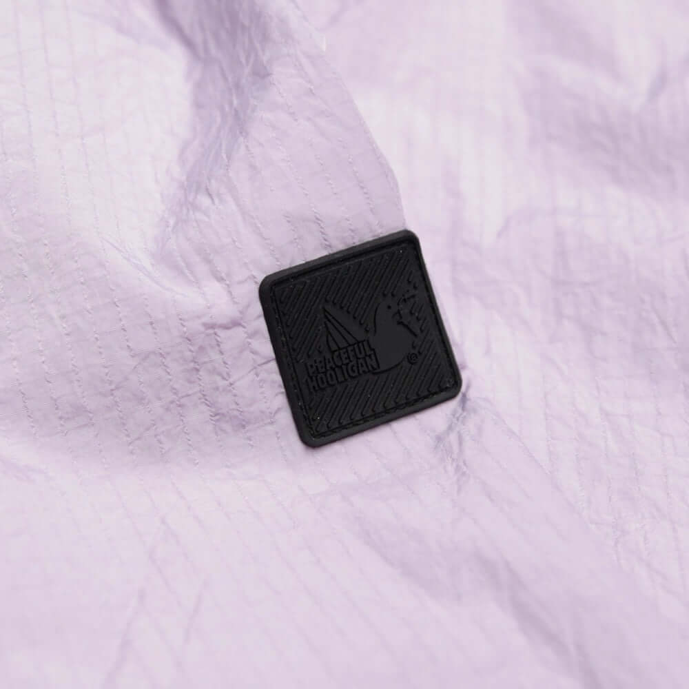 Close-up of the Dove Block badge on the Peaceful Hooligan PISTOL Jacket in Lavendula color.