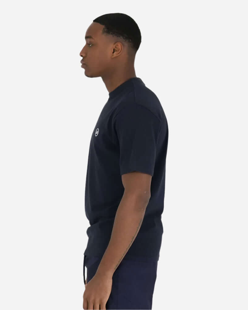 Man in navy Peaceful Hooligan SUMMER OF DOVE T shirt, showcasing a slim profile and logo detail.