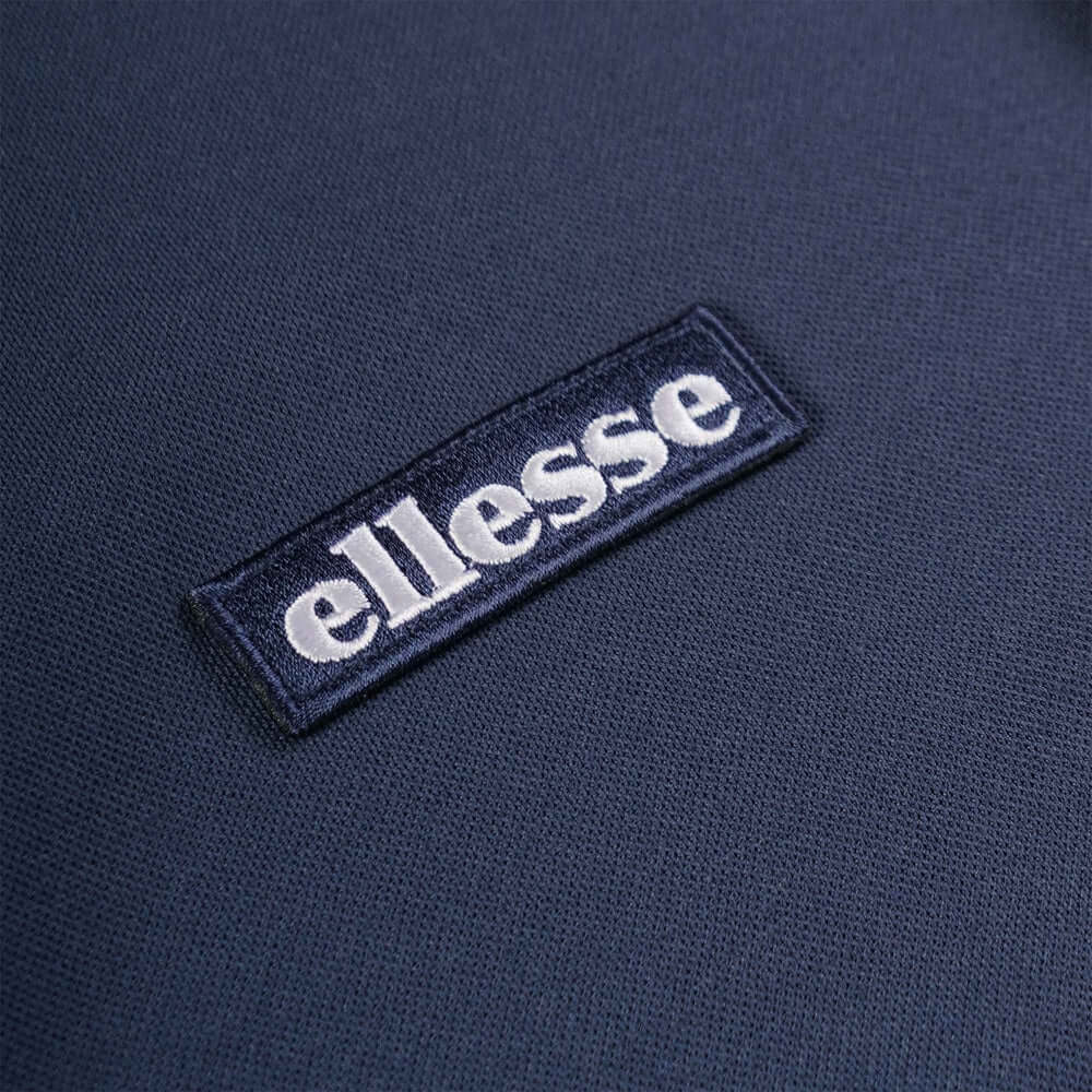 Ellesse logo detail on MACCHINO Polo Shirt Navy from Live Forever Collection, showcasing quality craftsmanship.