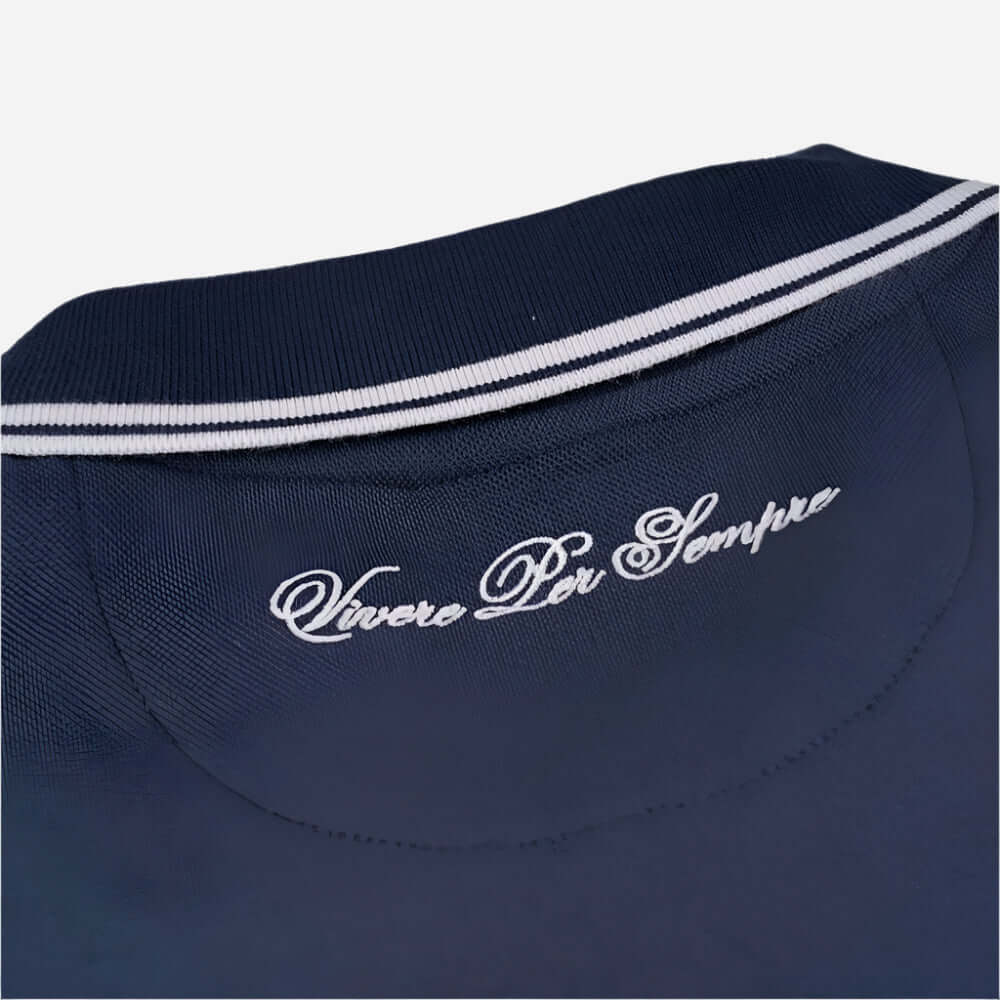 Close-up of the navy Ellesse MACCHINO Polo Shirt collar featuring 'Vivere Per Sempre' embroidery.