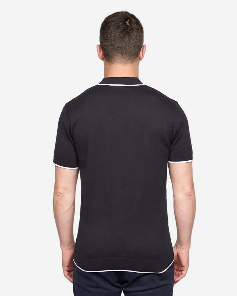 Back view of man wearing Gabicci Vintage LINEKER Polo Navy, showcasing its classic design and retro style.