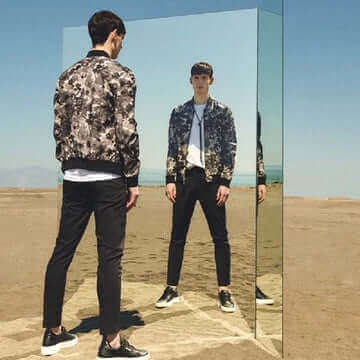 Antony Morato model in stylish jacket reflecting in a mirror at a desert location, showcasing Italian fashion.