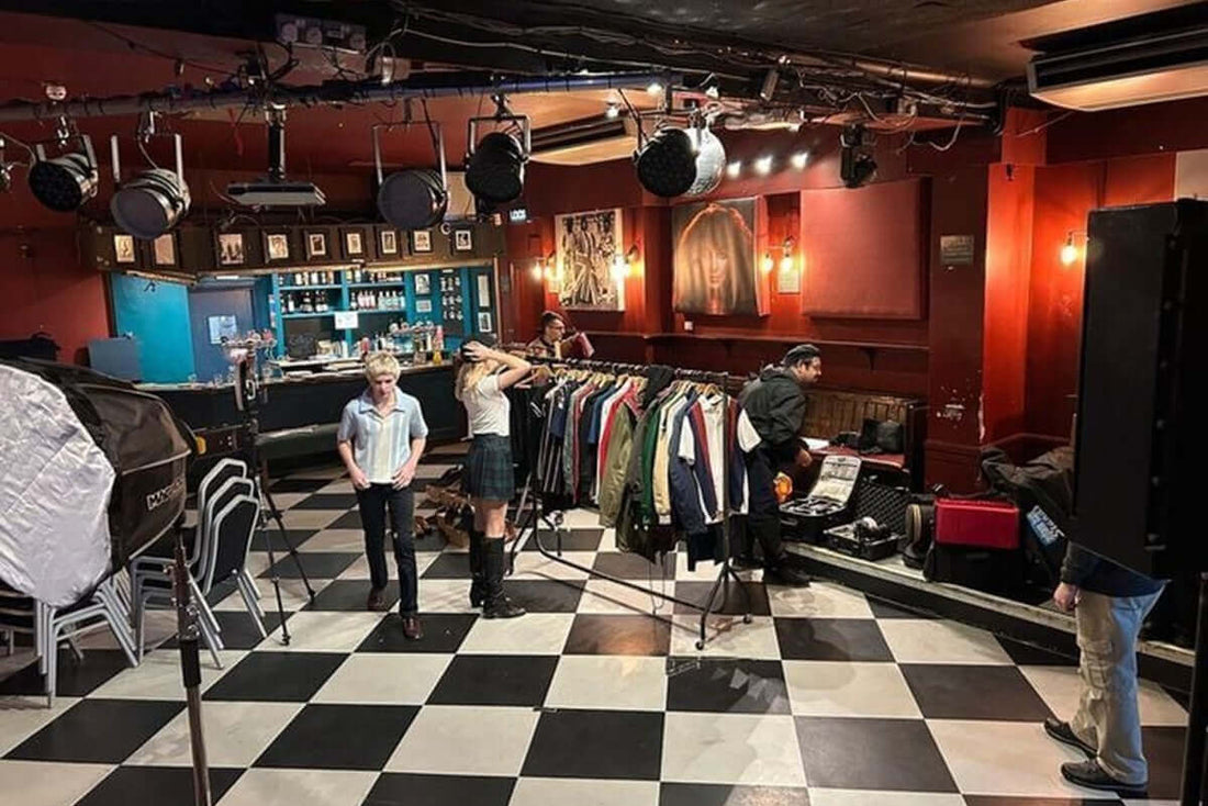 Merc London venue with models, clothing rack, and stage lights, showcasing classic style and cultural heritage.