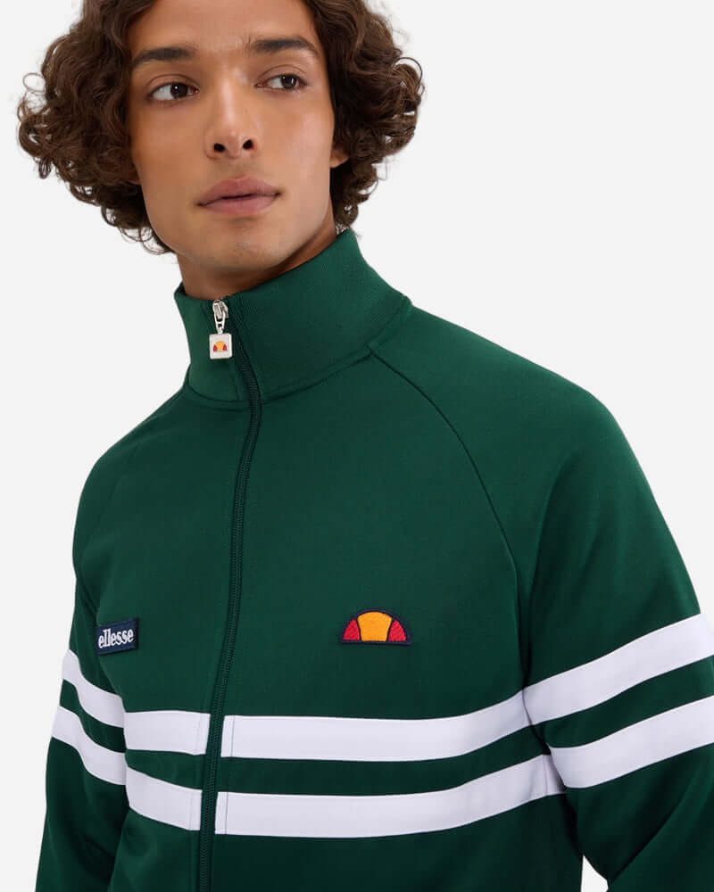 Ellesse RIMINI Track Jacket Dark Green worn by model, featuring funnel neck and contrast stripes.