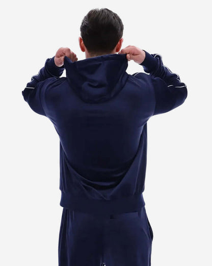 Back view of a man wearing a Fila Vintage ITALO Velour Hoodie Navy, showcasing the luxurious velour fabric and hood.