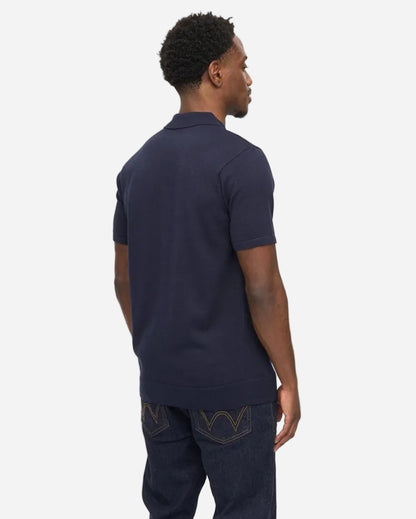 Man wearing Gabicci GUINESS Button-Through Polo in Navy, showcasing the back view and stylish design.