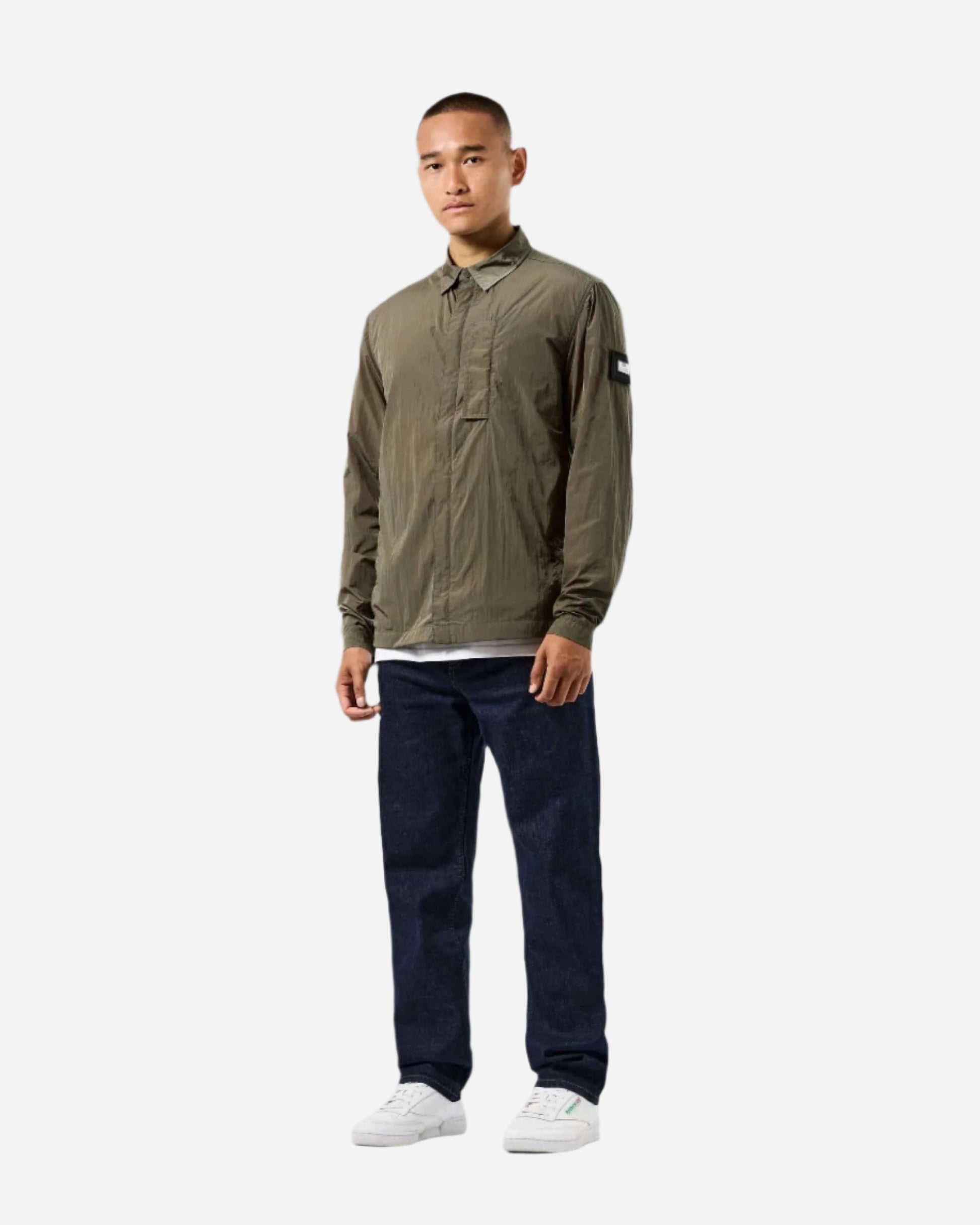 Model wearing Weekend Offender PORTER Overshirt in Castle Green, featuring storm placket and branded press stud collar, lightweight and versatile